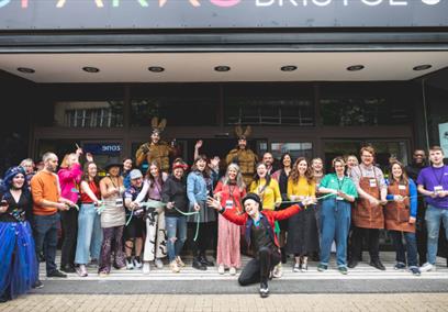A large group of people stood in a shop front doorway