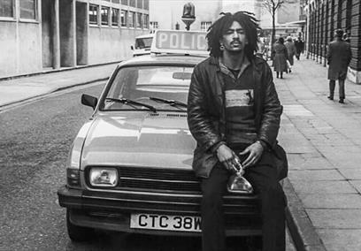Man sitting on car bonnet in black and white photo