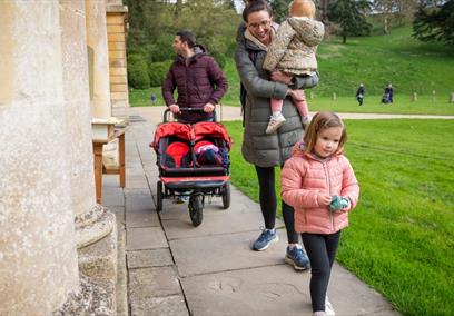 A family with a pushchair and Easter eggs outside the house at Dyrham Park