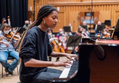 An image of a woman playing the piano