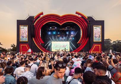Crowd watching performer on stage at dusk