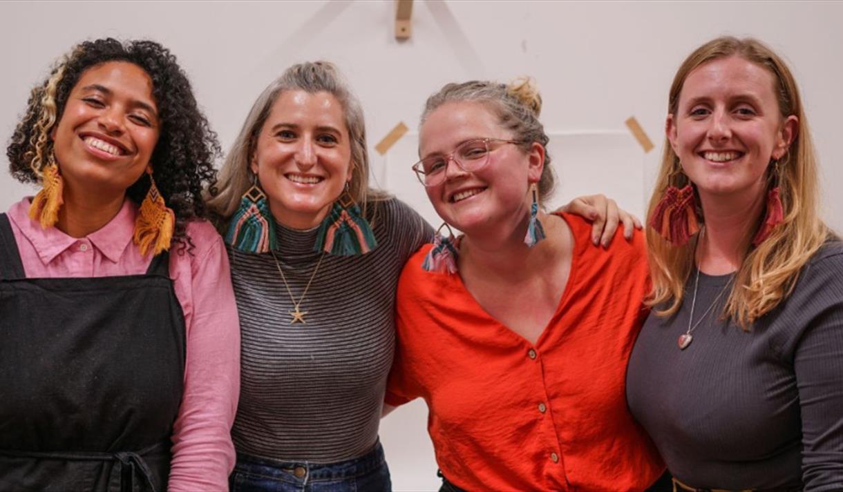 Four women wearing macrame earrings