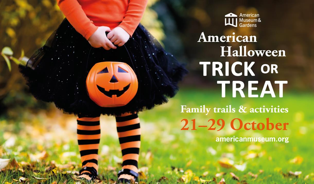 A little girl holding a Jack O'Lantern standing in a garden full of fallen leaves