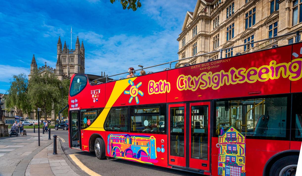 Red open-top tour bus in Bath