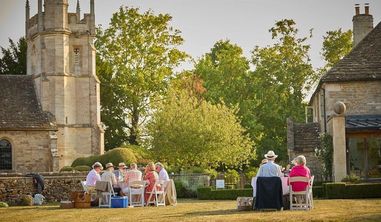 People sat outside in sunshine in countryside