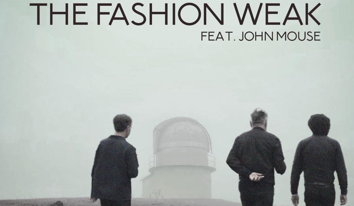 Three men walking towards a lighthouse in rain