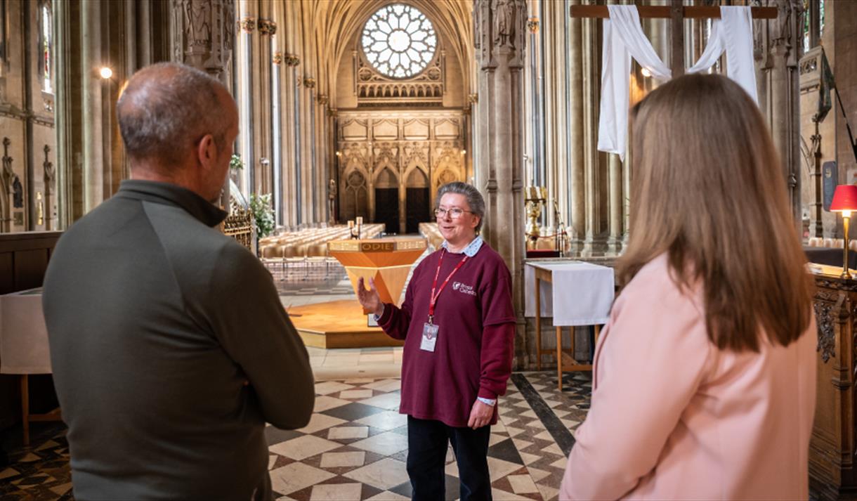 2 people standing with a volunteer from Bristol Cathedral