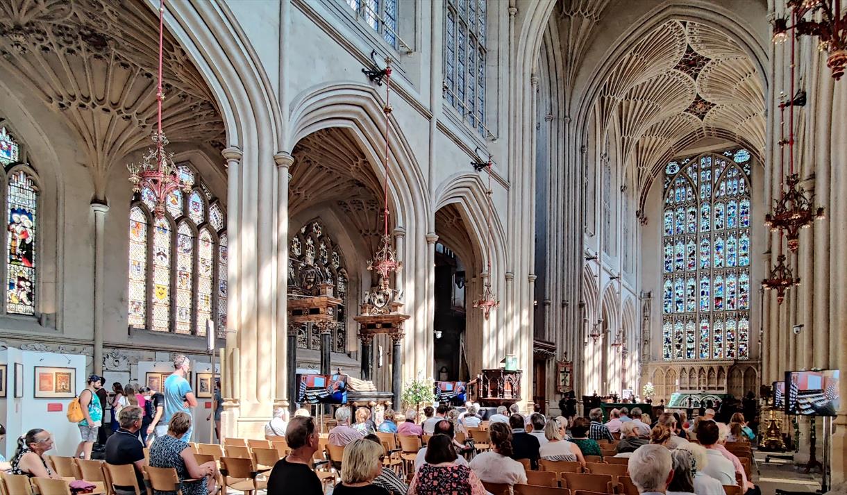 People sat in Bath Abbey listening to a music act