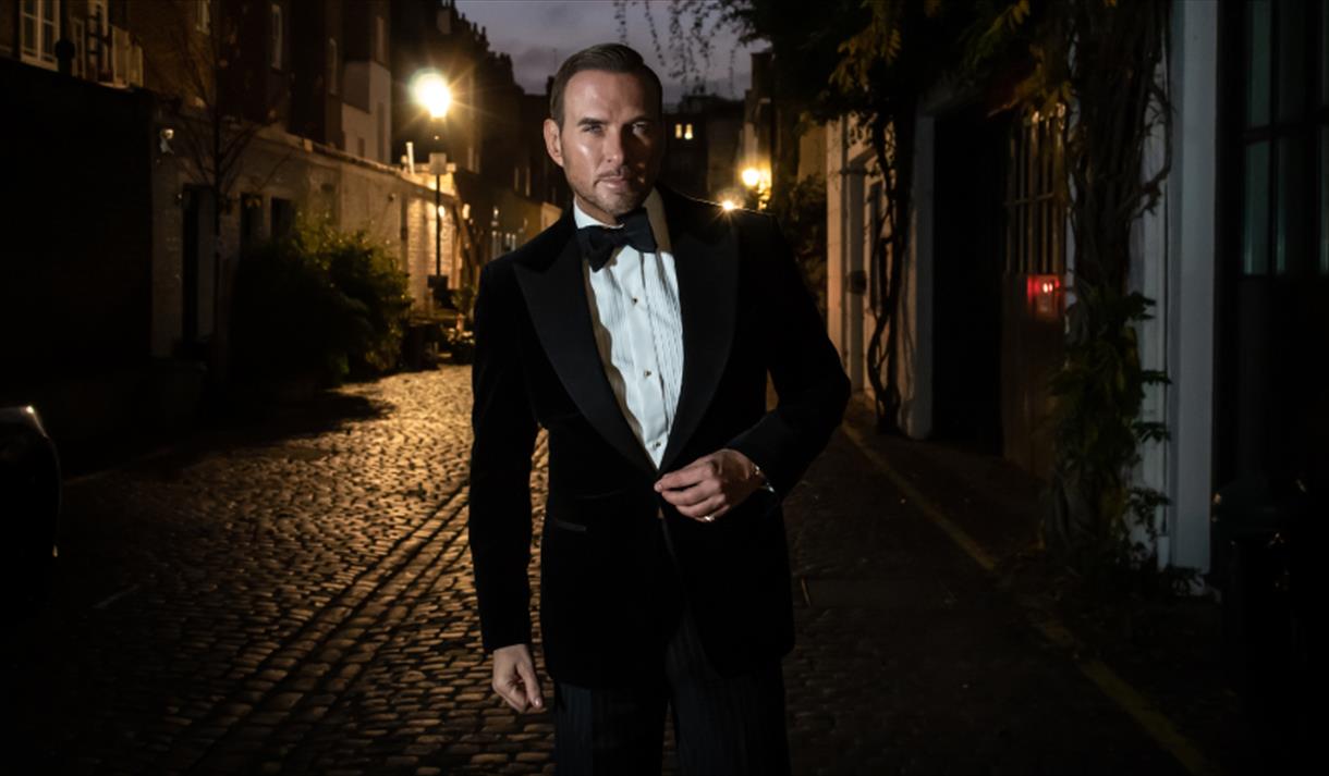 Matt Goss walking down a dimly lit street