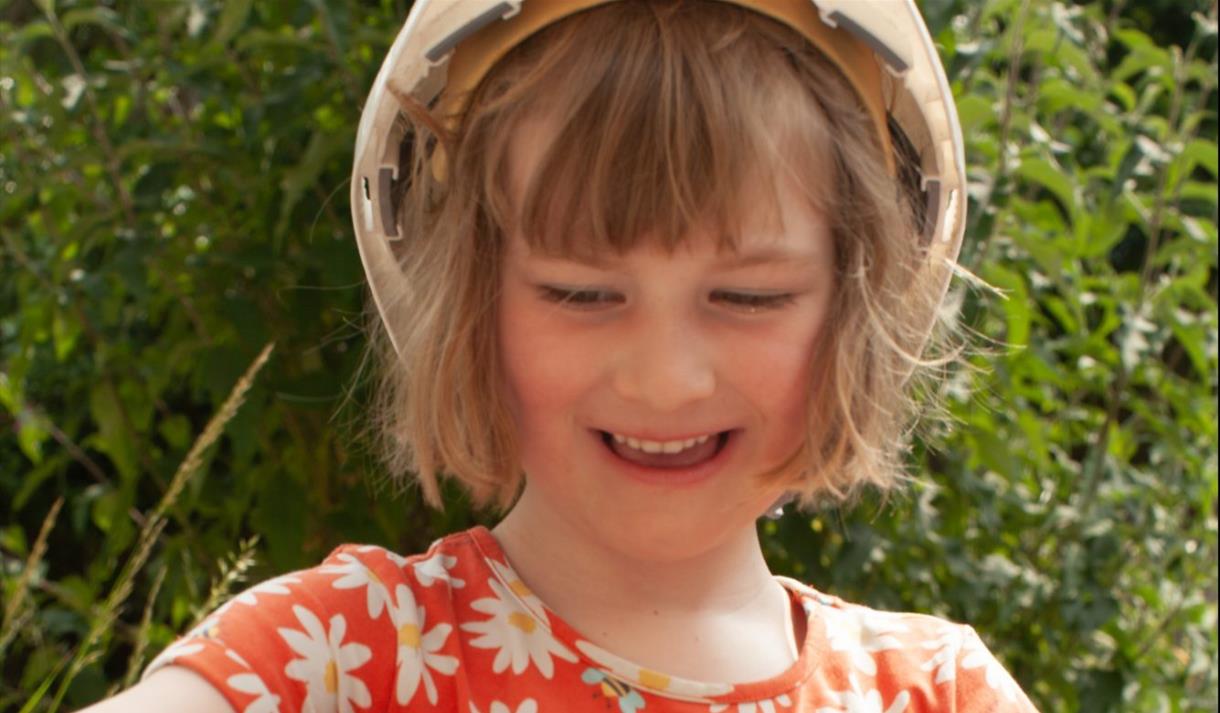 Young girl wearing a hard hat using clay