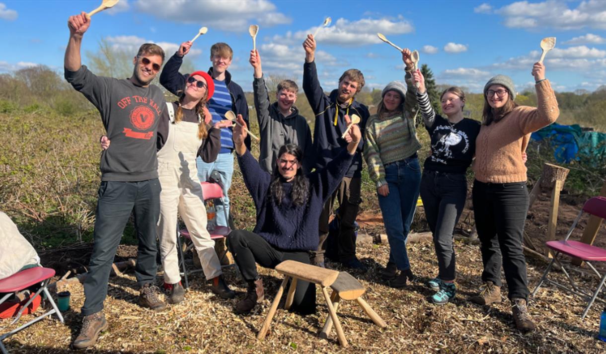 A group of people holding up wooden spoons