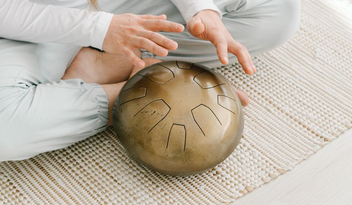 A pair of hands hovering above a gold bowl