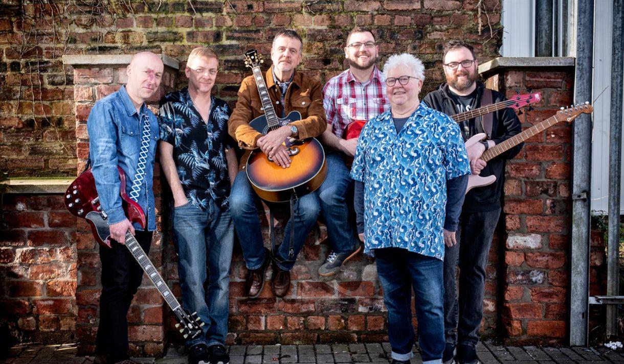 The Fun Lovin' Crime Writers band, posing with their instruments.