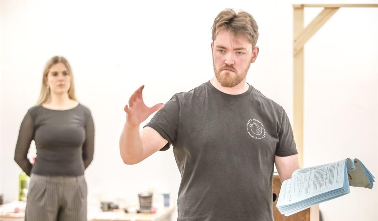 2 actors wearing grey tshirts in a white room