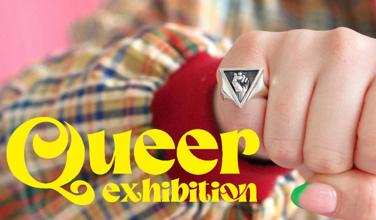 A picture of a fist with a ring and the words 'Queer Exhibition' overlaid in yellow text