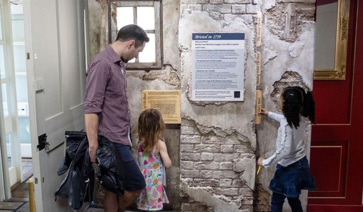 A family reading an information board at the New Room