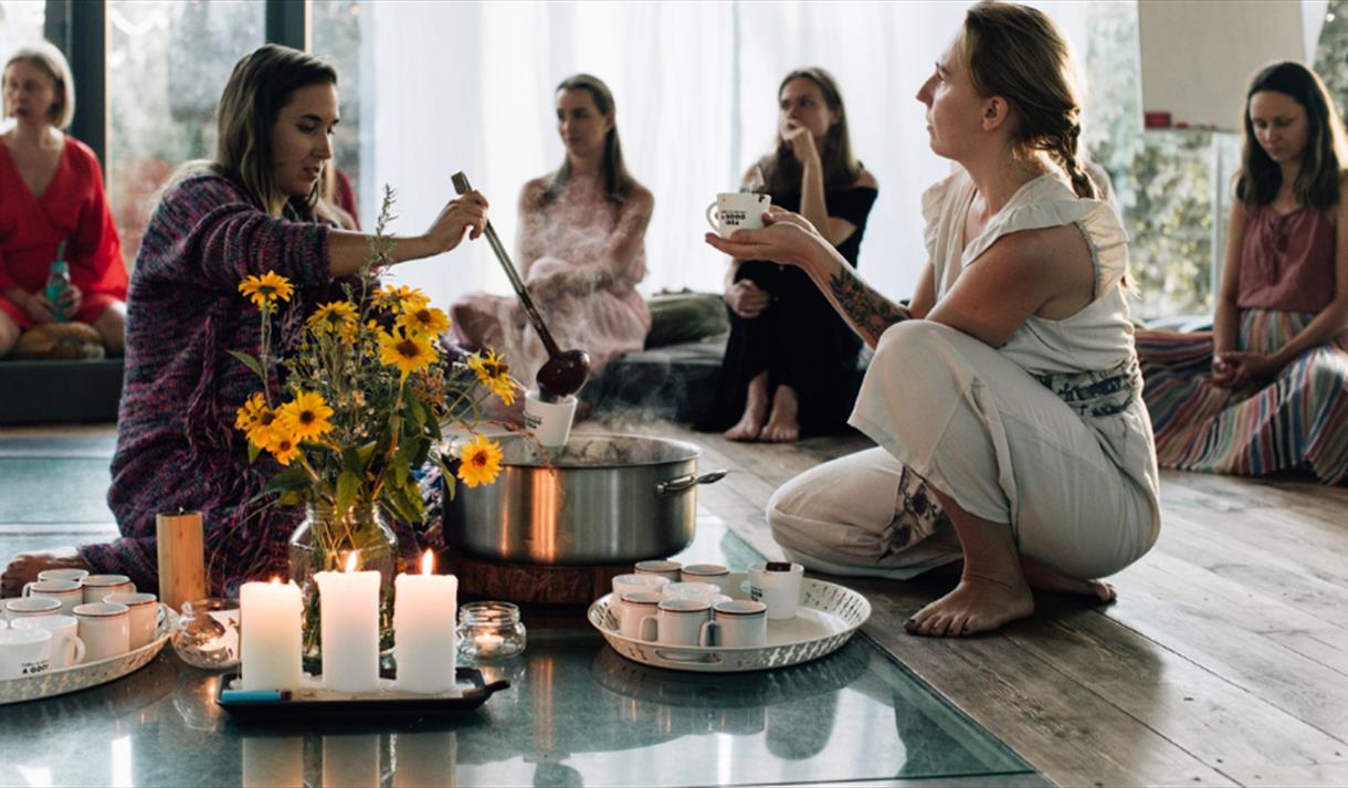 A group of women barefoot at a sound and tarot ceremony