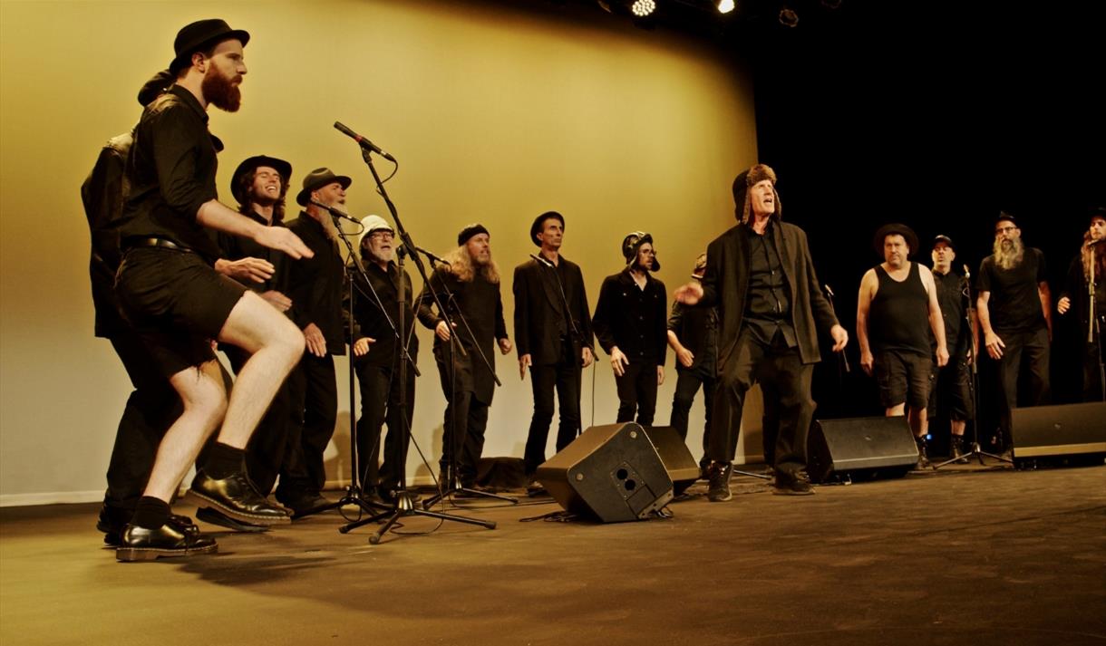 The Spooky Men's Chorale performing on stage.