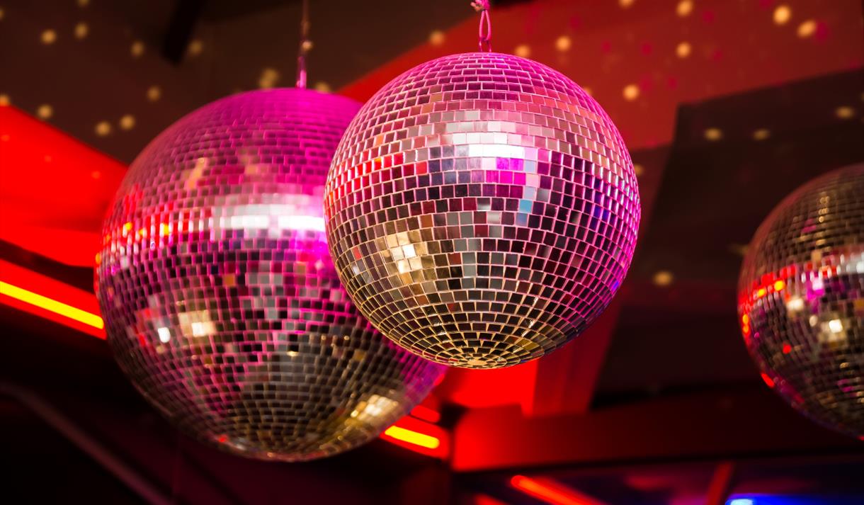 A mirrorball with pink lights shining on it