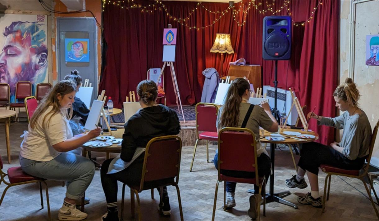 A group of women partaking in a painting workshop