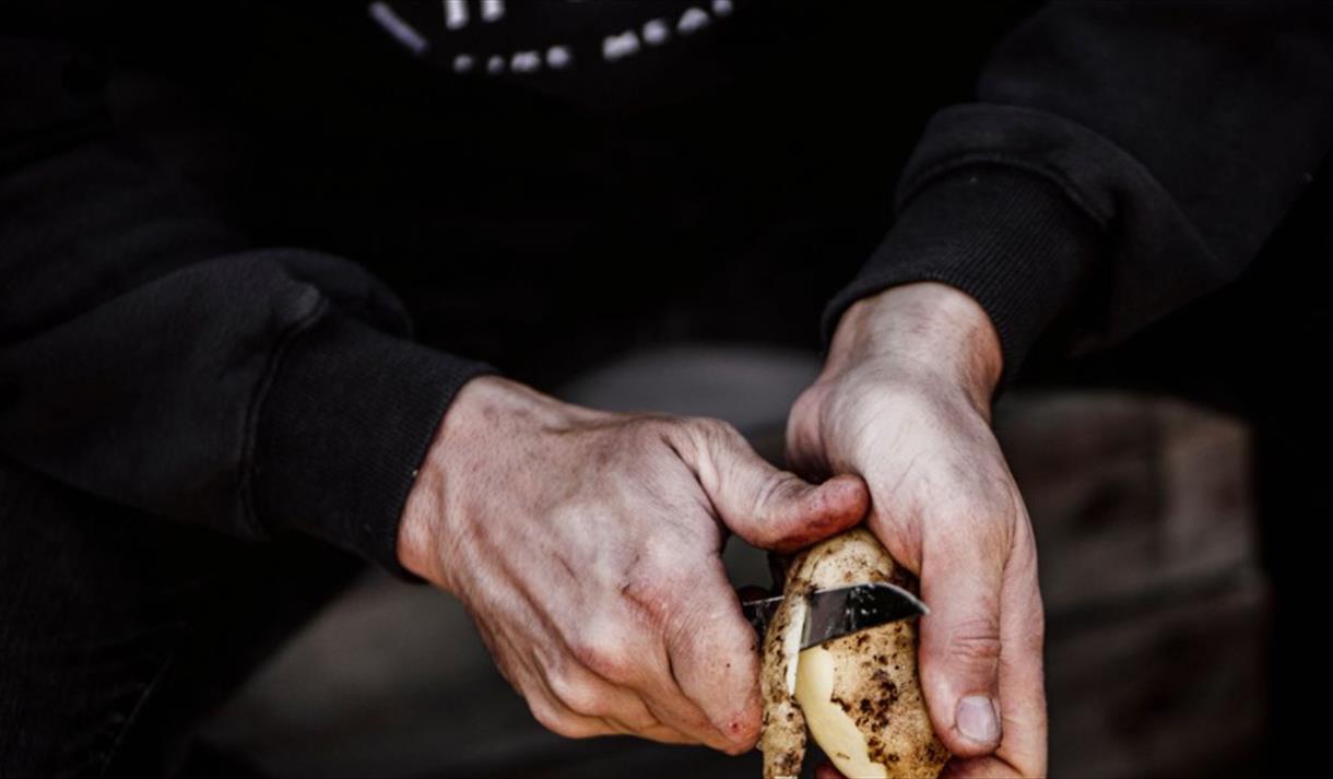 A man peeling a potato