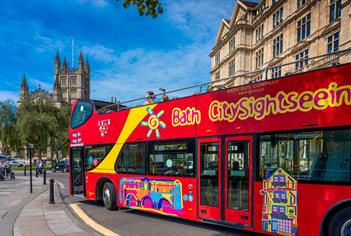 Red open-top tour bus in Bath