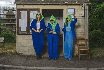 three women standing in a bus shelter