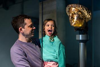 child and parent looking at statue of Minerva at The Roman Baths