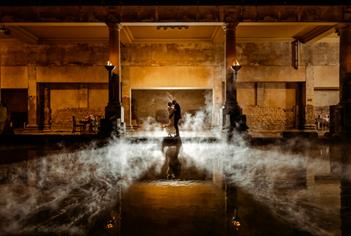 A newly married bride and groom alongside the Great Bath at The Roman Baths in Bath