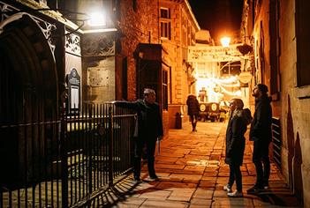 A tour guide pointing out a church to two participants
