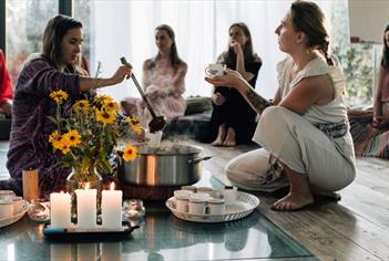 A group of women barefoot at a sound and tarot ceremony