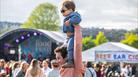 An image of a man holding up a young boy over his shoulders at the Foodies Festival.