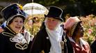 A man flanked by two women all wearing Jane Austen-themed costumes