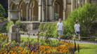 Two children in white t-shirts and shorts strolling round the gardens of a mansion