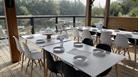 Cafe with tables and chairs with a view over the lake.