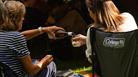 Two audience members sharing a bottle of wine at the Garden Theatre Festival in Bath.