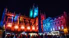 Bath Abbey lit in Christmas lights with market stalls in foreground
