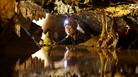 Girl in cave looking at stalactites