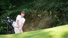 A man wearing all white playing golf