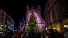 A large Christmas tree placed in centre of a square with Bath Abbey in the background