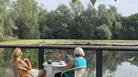 two ladies sitting and having a cup of tea near a lake