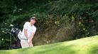 A man wearing all white playing golf