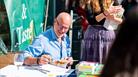 A man signing books and smiling