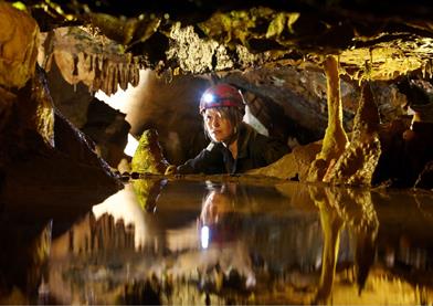 Girl in cave looking at stalactites