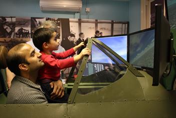 Maidenhead Heritage Centre: man and boy enjoying the Spitfire Simulator