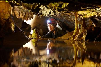 Girl in cave looking at stalactites