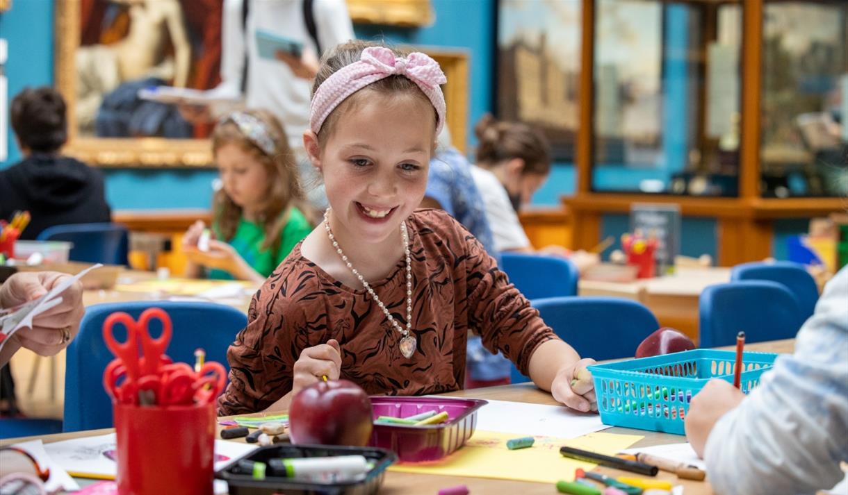 Girl working on a craft project at a table in the Victoria Art Gallery Girl working on a craft project at a table in the Victoria Art Gallery