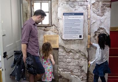 A family reading an information board at the New Room