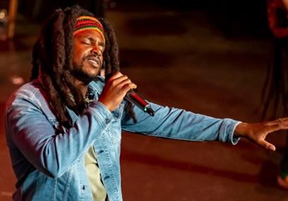 Actor singing dressed as Bob Marley