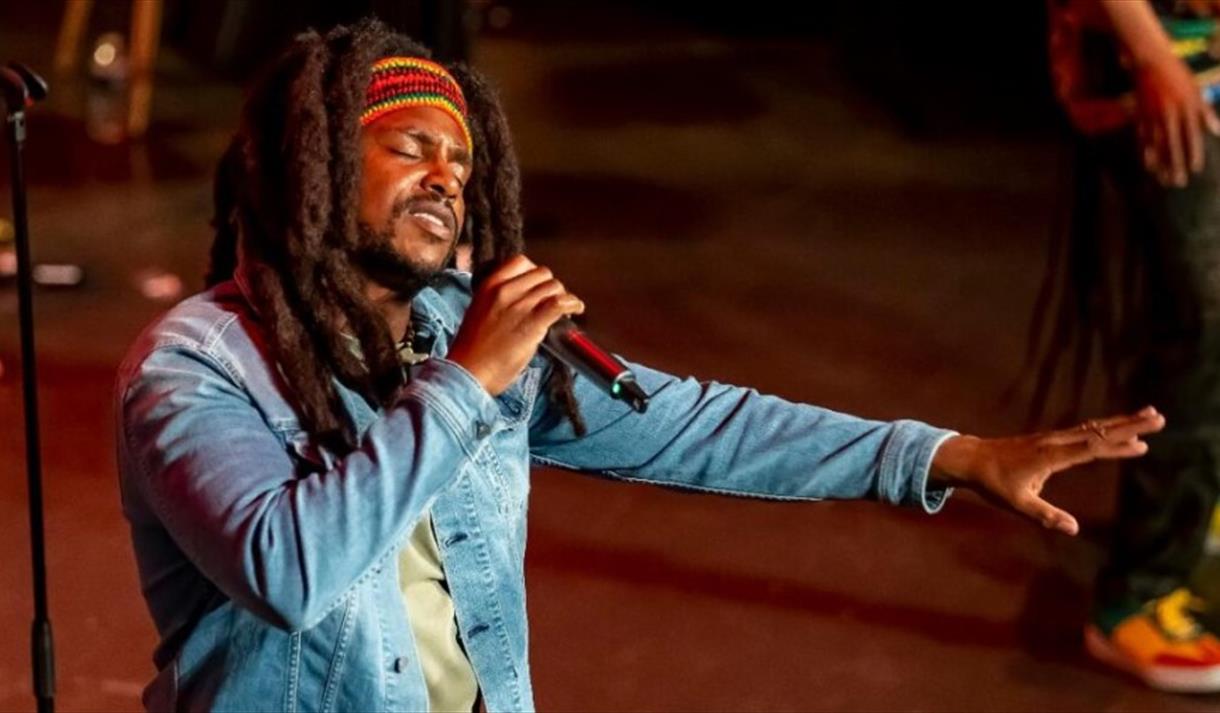 Actor singing dressed as Bob Marley